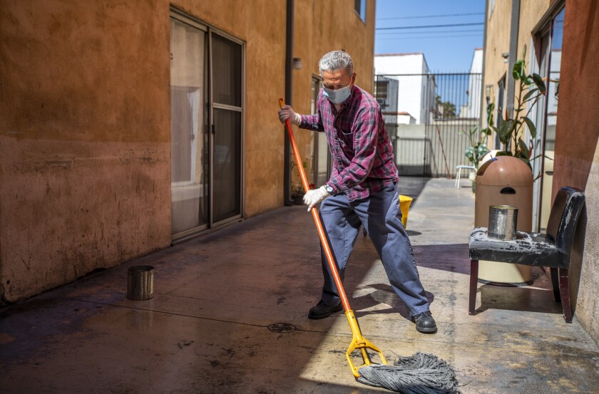 A man mops an outdoor area.