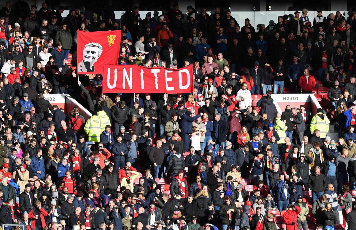 Manchester United fans hold a banner depicting the team's manager Jose Mourinho ahead of a match against Arsenal at Old Trafford in Manchester on Nov. 19.