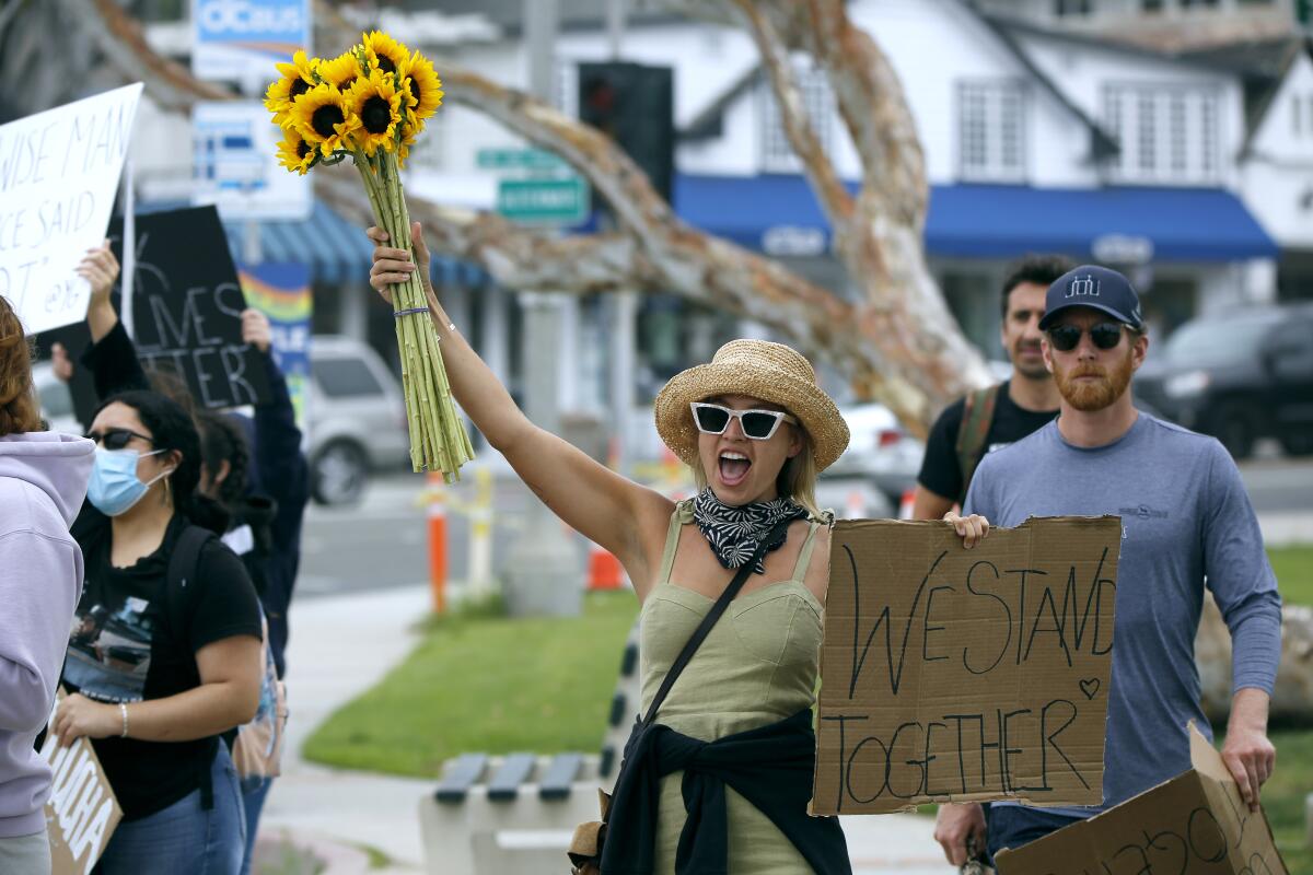 Helen Kramer, 28, brought flowers and a sign to a Black Lives Matter protest at Main Beach Park.
