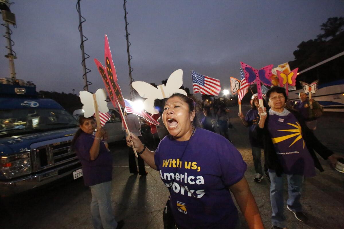 Maria Ortiz, who works as a janitor, shouts slogans at an immigration rally held at the Dodger Stadium parking lot before their departure to Bakersfield for a bigger rally later Wednesday.