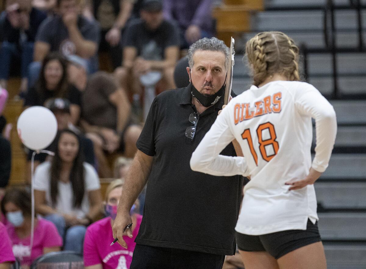 Huntington Beach head coach Craig Pazanti talks to Meghan Freck during a Sunset Conference crossover match on Sept. 28.