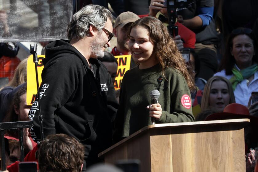LOS ANGELES, CA -- FEBRUARY 07, 2020: Joaquin Phoenix introduces Nalleli Cobo during a City Hall protest. She was recently diagnosed with a rare cancer spurring an outpouring of community support. Cobo believes her ailments are linked to the Allenco oil drill site in her University Park neighborhood. (Myung J. Chun / Los Angeles Times)