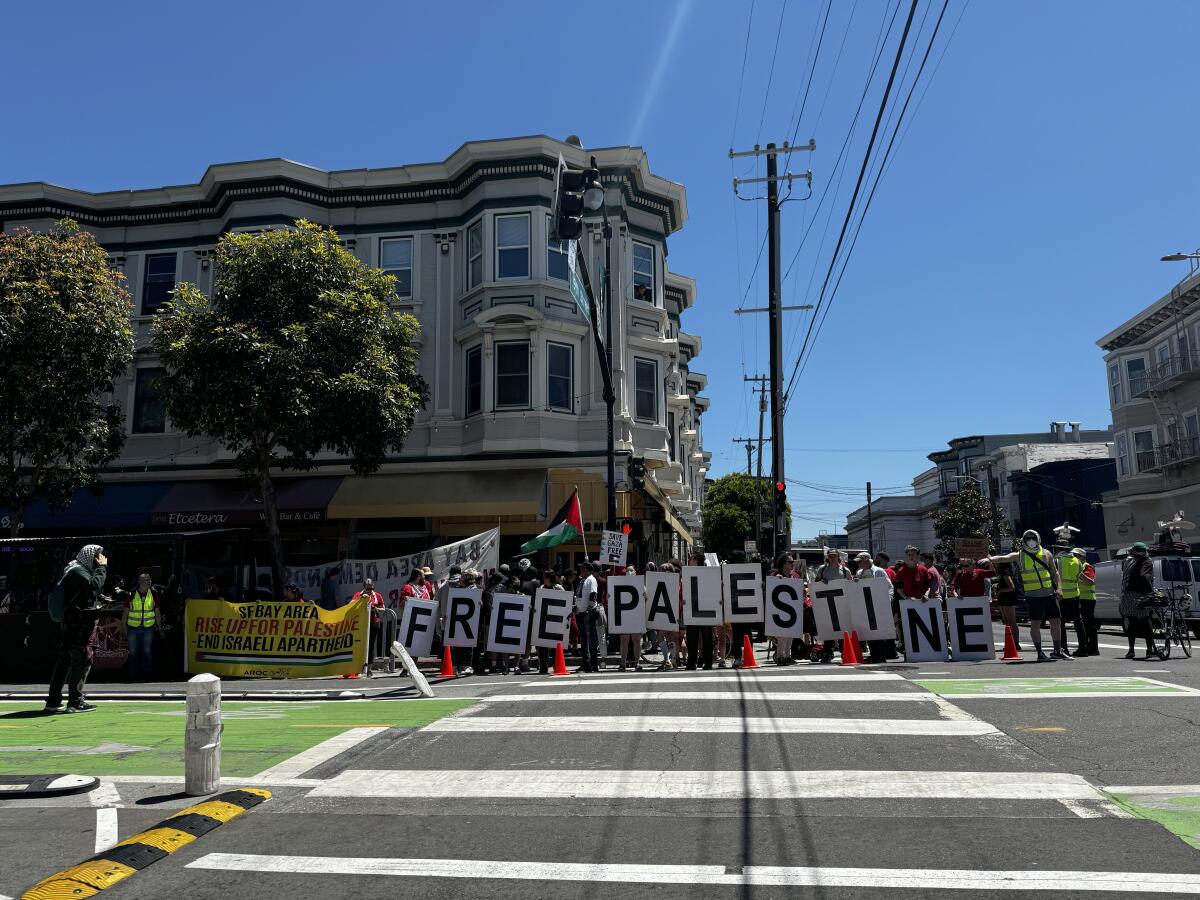 Demonstrators hold signs spelling "Free Palestine" on a sidewalk in San Francisco