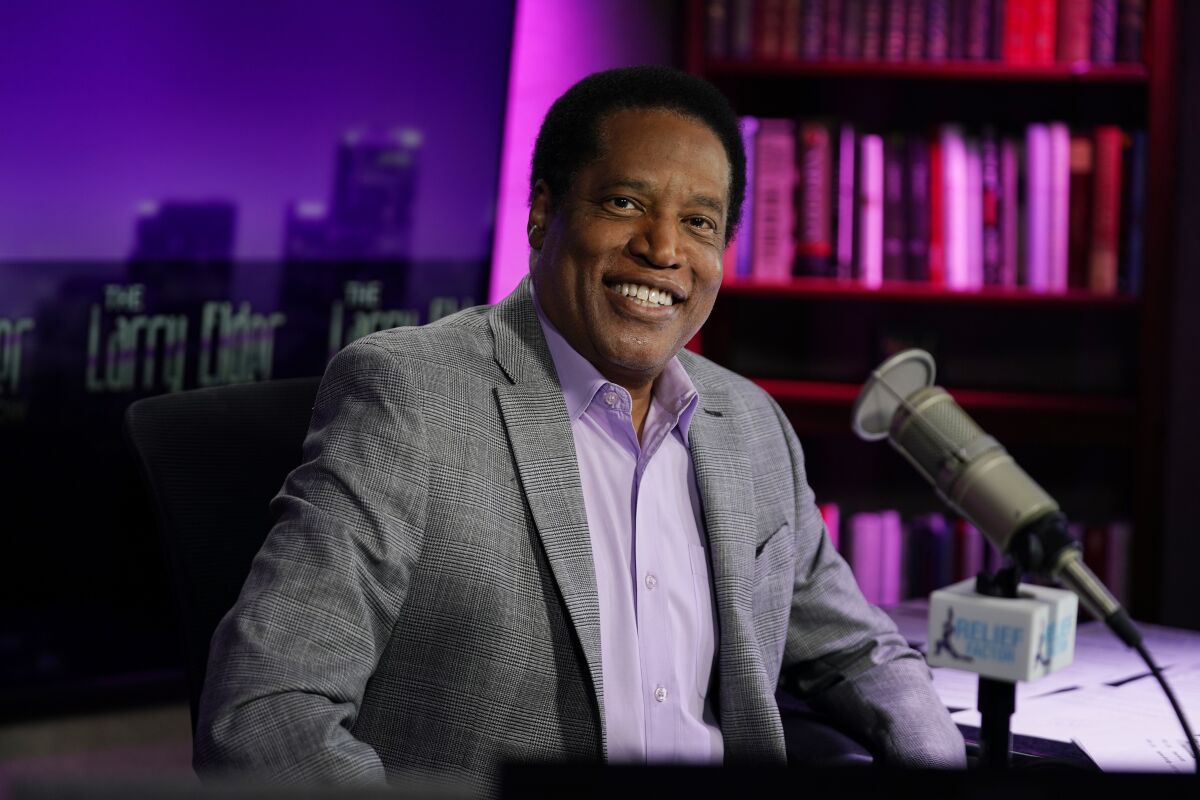 FILE - In this July 12, 2021 file photo, radio talk show host Larry Elder poses for a photo in his studio in Burbank, Calif. Elder, the leading Republican candidate in the California recall election that could remove Democratic Gov. Gavin Newsom from office, reported income of over $100,000 in the last year from business interests that included media and film companies and a string of speeches to Republican and conservative groups, documents showed Tuesday, Aug. 17, 2021. (AP Photo/Marcio Jose Sanchez, File)