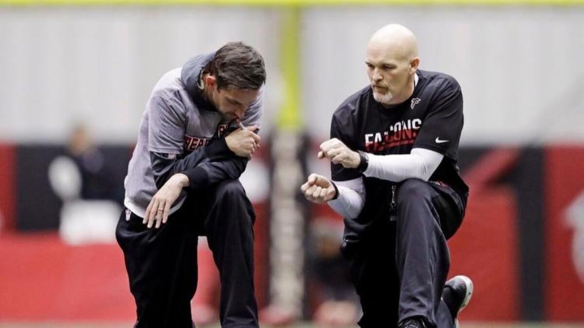 Atlanta Falcons offensive coordinator Kyle Shanahan, left, talks with Coach Dan Quinn during a workout in Georgia on Jan. 27.