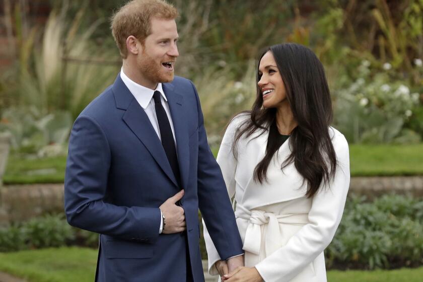 FILE - In this file photo dated Monday Nov. 27, 2017, Britain's Prince Harry and fiancee Meghan Markle pose for photographers during a photocall in the grounds of Kensington Palace in London, marking the couple's engagement to marry. Now with only a week until the May 19 wedding of Prince Harry and Meghan Markle, a party atmosphere is developing in the English city of Windsor, with tens of thousands of visitors expected in the city on the coupleâs wedding day. (AP Photo/Matt Dunham, FILE)