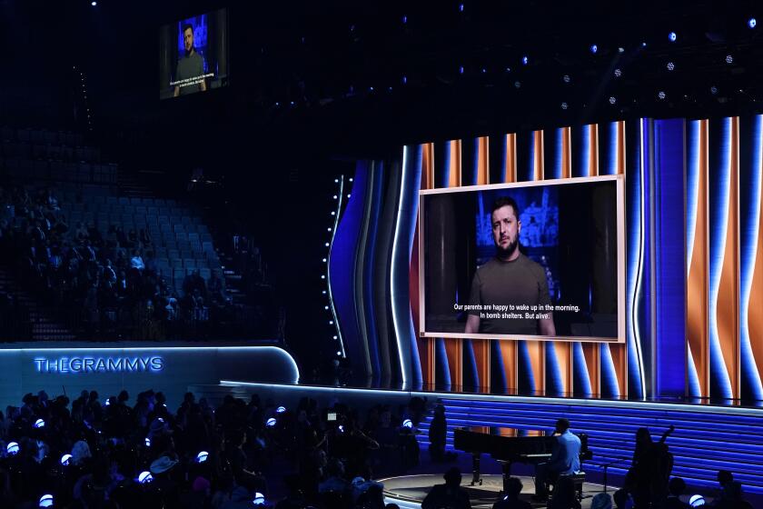 El presidente ucraniano Volodymyr Zelenskyy, en la pantalla, envía un mensaje transmitido durante la ceremonia de los premios Grammy, el domingo 3 de abril de 2022 en Las Vegas. (Foto AP/Chris Pizzello)