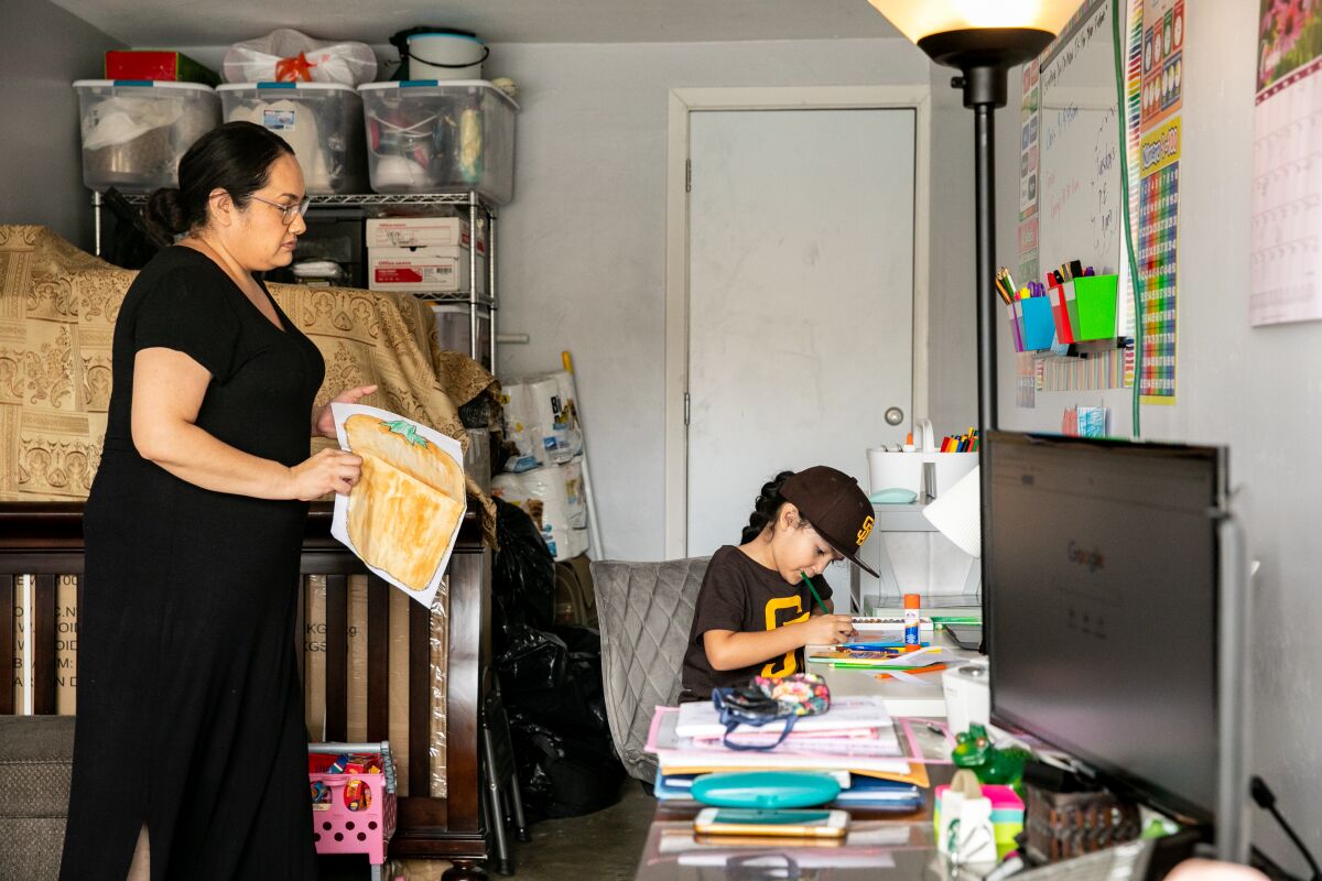 Zoey Castillo, 5, takes part in distance learning alongside her mother, Karla Ramirez, in their garage in City Heights.