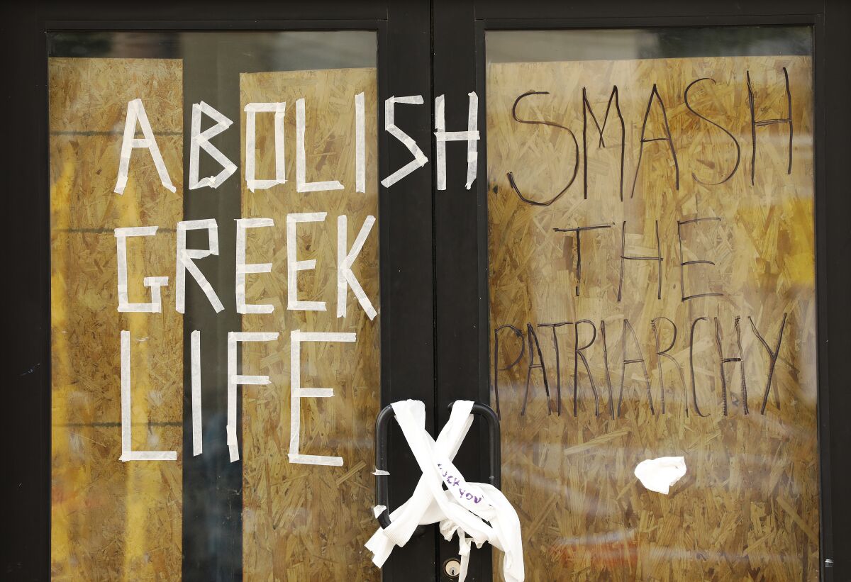 Angry notes and signs plaster the Sigma Nu frat house.