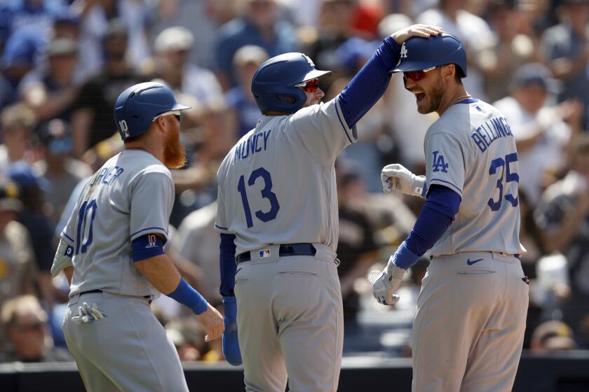 Los Angeles Dodgers' Cody Bellinger, right, celebrates with teammates Justin Turner, left, and Max Muncy (13) after hitting a three-run home run against the San Diego Padres during the fifth inning of a baseball game Sunday, April 24, 2022, in San Diego. (AP Photo/Mike McGinnis)