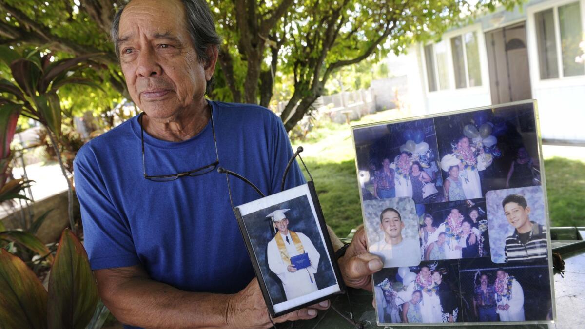 Clifford Kang, father of soldier Ikaika Kang, poses with photos of his son in Kailua, Hawaii, in 2017.