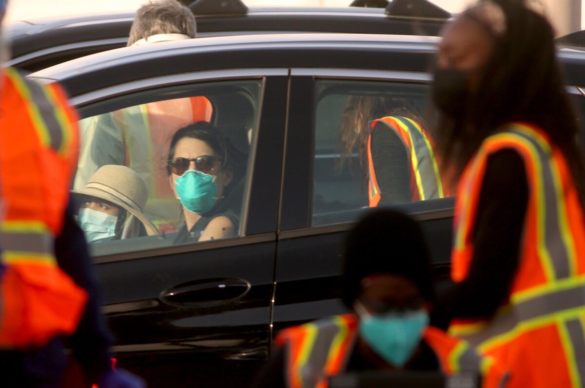 Motorists wait for a COVID-19 vaccine dose at a mass inoculation site in Northridge on Jan. 14. 