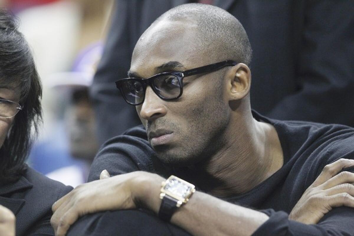 Injured Lakers star Kobe Bryant watches from the bench during the team's 96-85 loss to the New Orleans Pelicans on Friday.