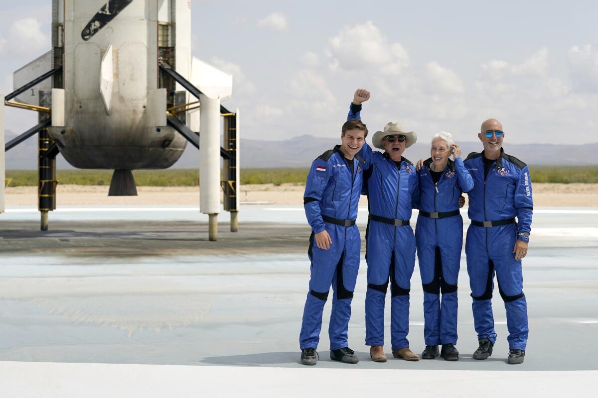 Jeff Bezos, wearing a cowboy hat, poses with other members of the first manned spaceflight by his company Blue Origin.