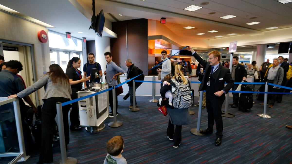 Passengers line up to board American Airlines 2381 flight to Orlando, Fla., at LAX. Shares of airlines stock have continued to climb despite a series of scandals over the last few months.