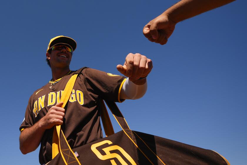 San Diego Padres third baseman Graham Pauley fist-bumps a member of the Padres staff as he arrives before a spring training baseball game against the Chicago White Sox, Saturday, March 9, 2024, in Peoria, Ariz. (AP Photo/Lindsey Wasson)