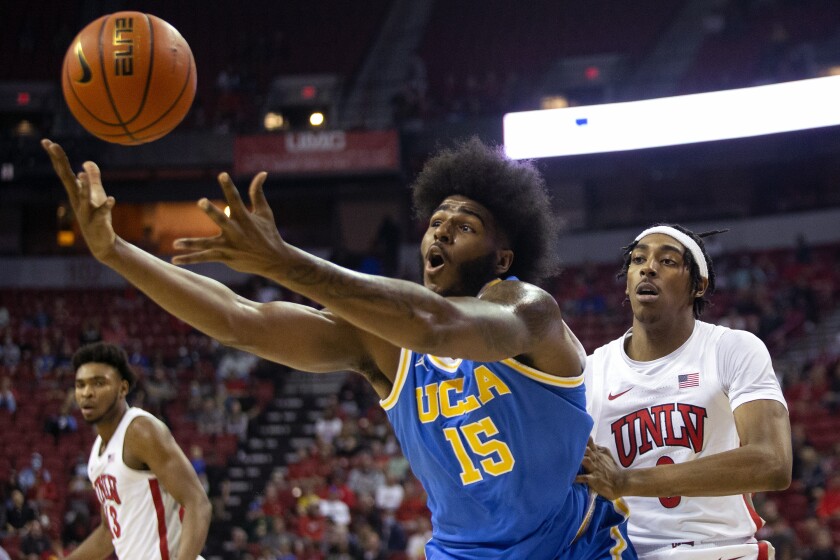 UCLA center Myles Johnson (15) loses control of the ball while UNLV forward Donovan Williams, right, defends during the first half of an NCAA college basketball game Saturday, Nov. 27, 2021, in Las Vegas. (Ellen Schmidt/Las Vegas Review-Journal via AP)