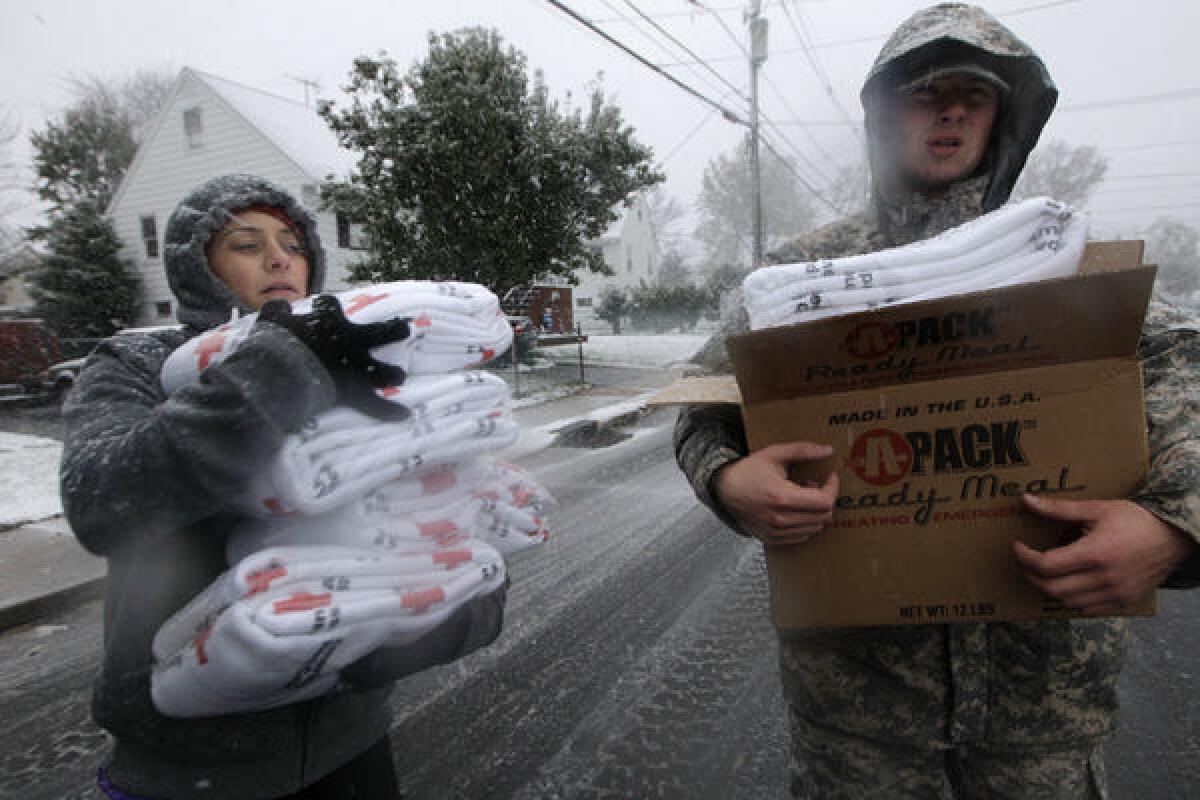 Volunteer Karina Ayubi and National Guardsman Brandon Kyle distribute blankets donated by the American Red Cross to residents without power in the wake of Superstorm Sandy in Little Ferry, N.J.