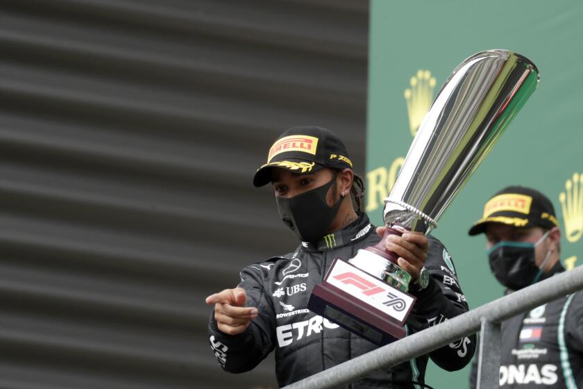 Mercedes driver Lewis Hamilton of Britain celebrates on the podium after winning the Formula One Grand Prix at the Spa-Francorchamps racetrack in Spa, Belgium, Sunday, Aug. 30, 2020. (Stephanie Lecocq, Pool via AP)