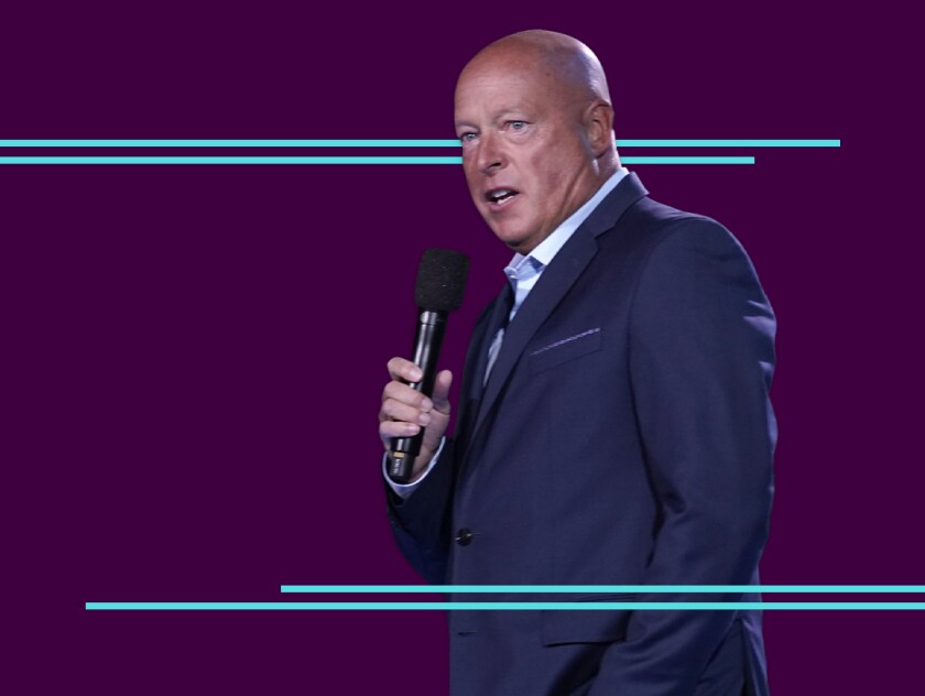 Disney CEO Bob Chapek holds a microphone while speaking.