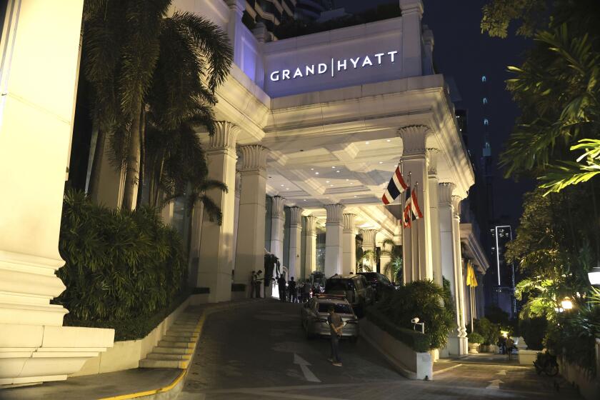 A man walks outside the Grand Hyatt Erawan Hotel in Bangkok, Thailand, Tuesday, July 16, 2024. Police said a number of people were found dead Tuesday in the luxury hotel in downtown Bangkok and poisoning is suspected. (AP Photo/Chatkla Samnaingjam)