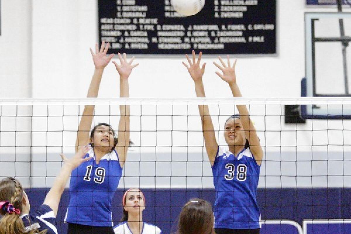San Marino's Cherie Chow, left, and Kelly Truong set up a block on a Flintridge Prep kill attempt, while Titans setter Amanda Yee, center, reads the ball.