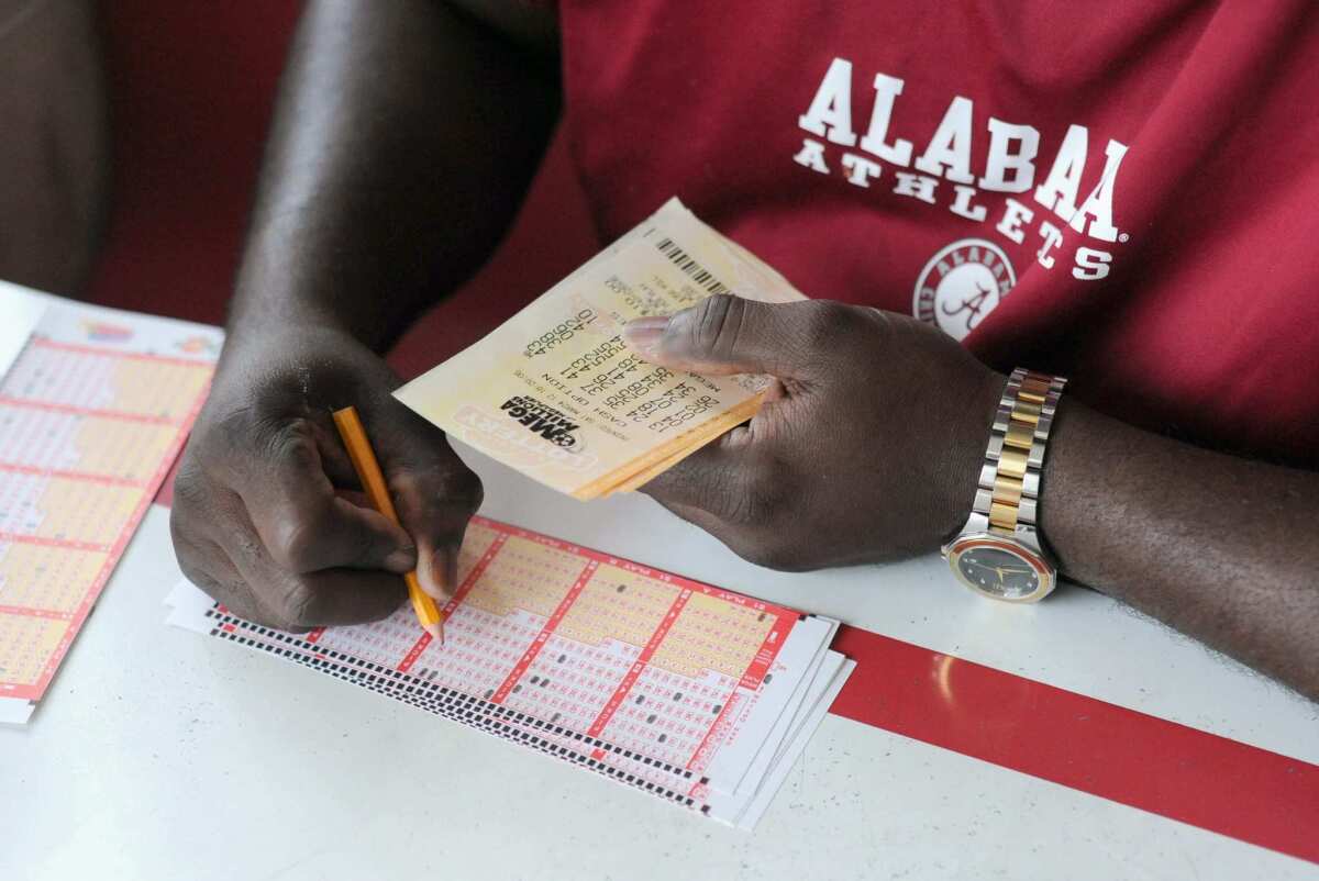 Anthony Payne of Birmingham, Ala., fills in his play slip to purchase lottery tickets at Robinson's convenience store in Tallapoosa, Ga., near the Alabama state line.