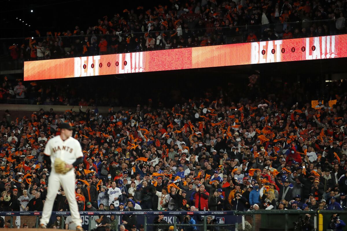 Fans cheer as San Francisco Giants pitcher Logan Webb stands on the mound during the seventh inning of Game 1 of a baseball National League Division Series against the Los Angeles Dodgers Friday, Oct. 8, 2021, in San Francisco. (AP Photo/John Hefti)