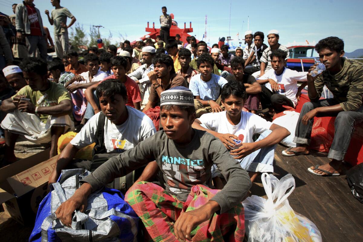 Rescued Rohingya migrants from Myanmar wait at a port in Aceh, Indonesia, after their boat was hobbled in a storm.