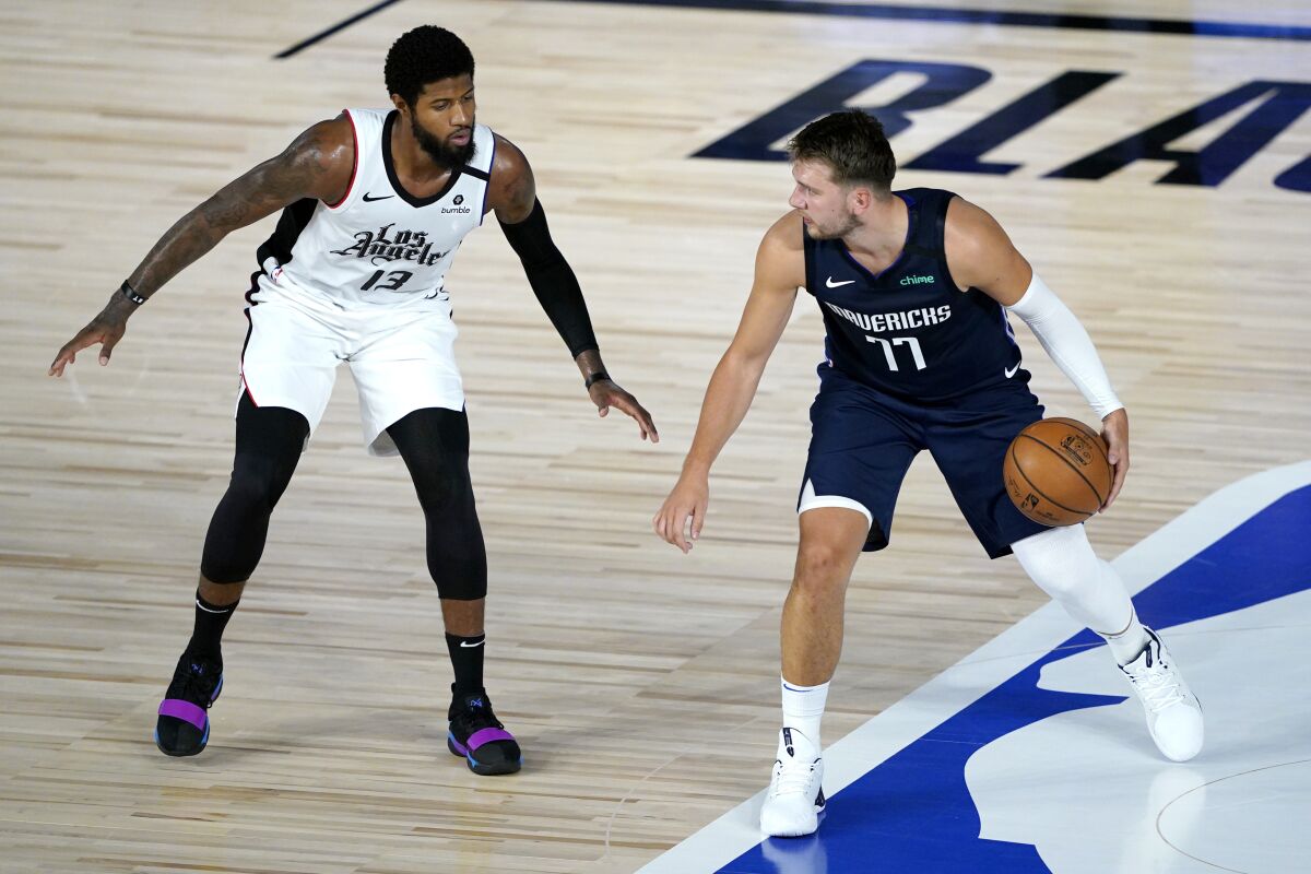 Dallas Mavericks forward Luka Doncic tries to work past Clippers forward Paul George during a game on Aug. 6.