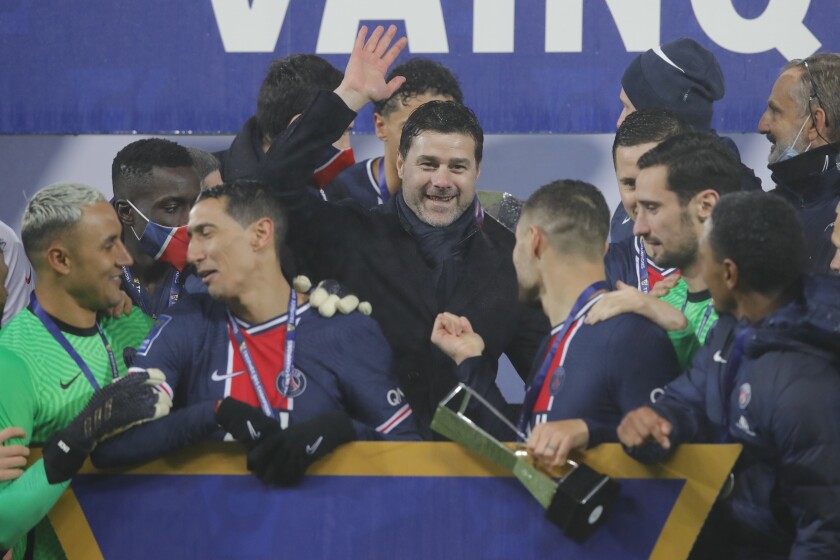 PSG's head coach Mauricio Pochettino, center, and PSG players celebrate with the trophy after the Champions Trophy soccer match between Paris Saint-Germain and Olympique Marseille at the Bollaert stadium in Lens, northern France, Wednesday, Jan.13, 2021. PSG won 2:1. (AP Photo/Christophe Ena)