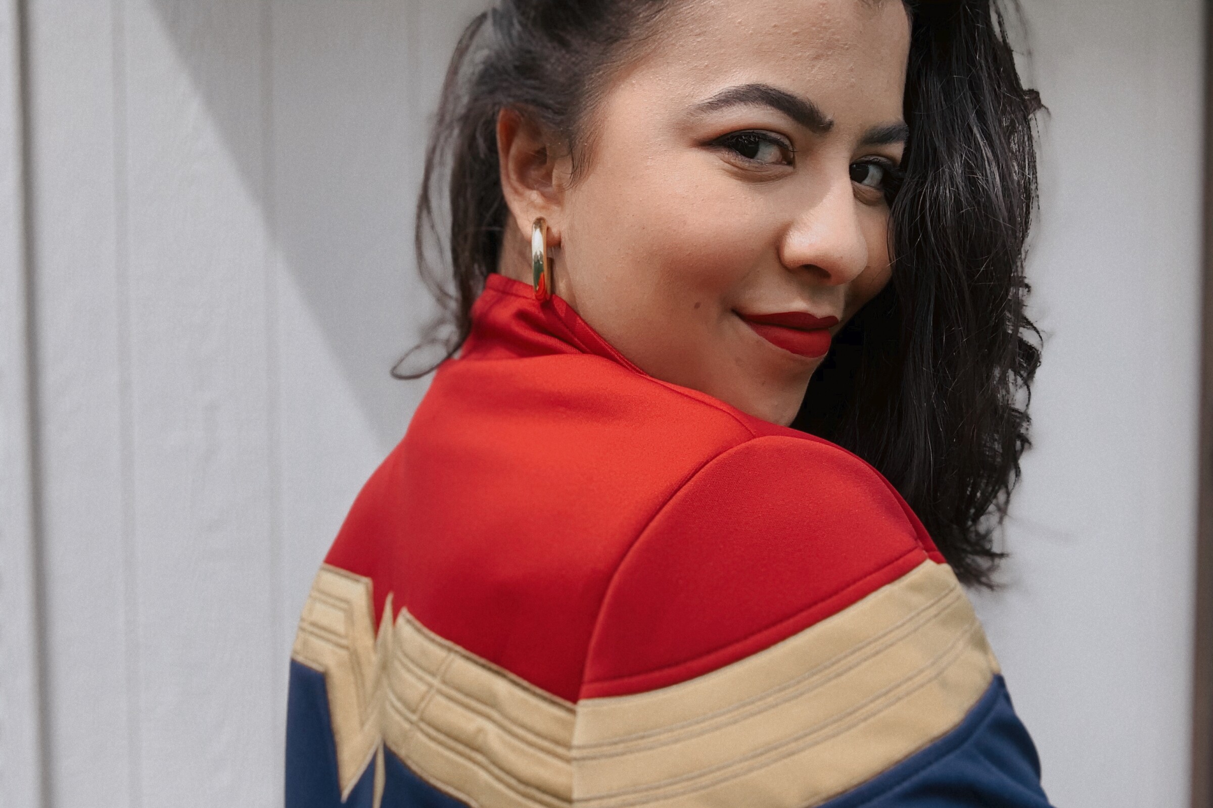 Designer Adria Renee models the Wonder Woman 1984 logo track jacket.