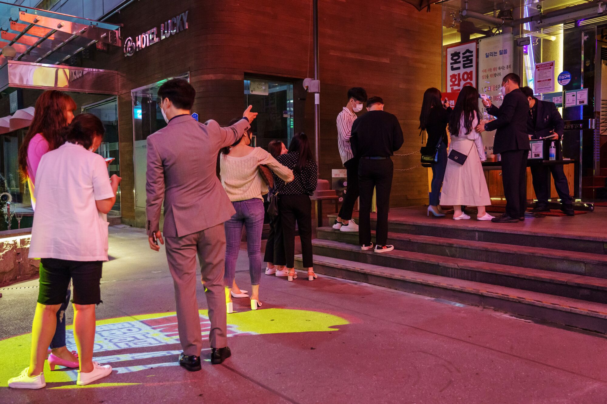 A line stretches outside Nightclub Seven in Daejeon, South Korea, as customers figure out the new QR code registry.