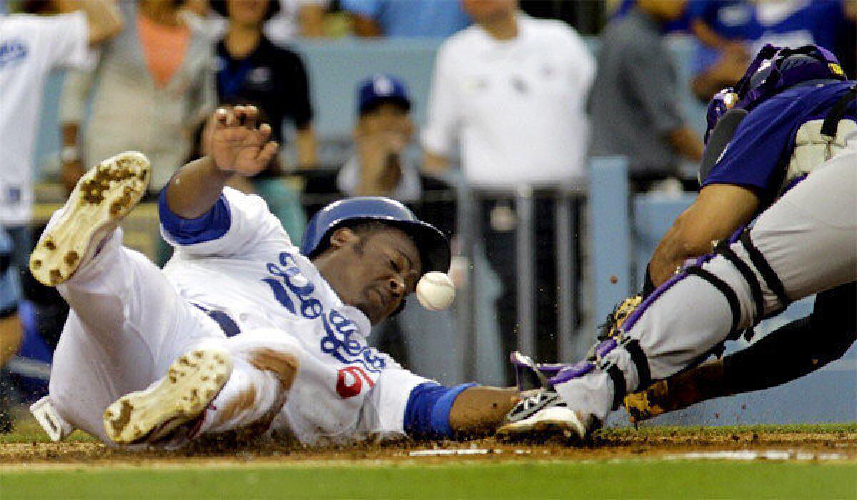 Juan Uribe slides safely into home as Colorado catcher Wilin Rosario loses the ball during the Dodgers' 6-1 victory over the Rockies on Thursday.