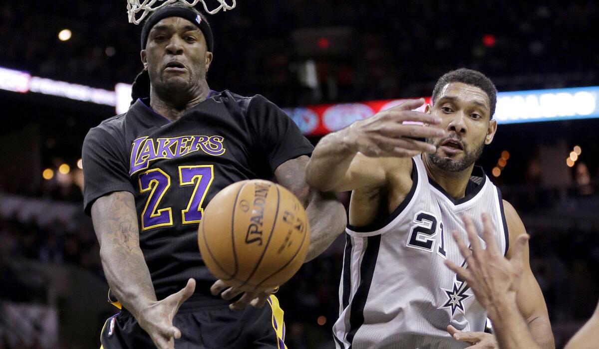 Lakers center Jordan Hill (27) and Spurs forward Tim Duncan scramble for a rebound in the first half Friday night in San Antonio.