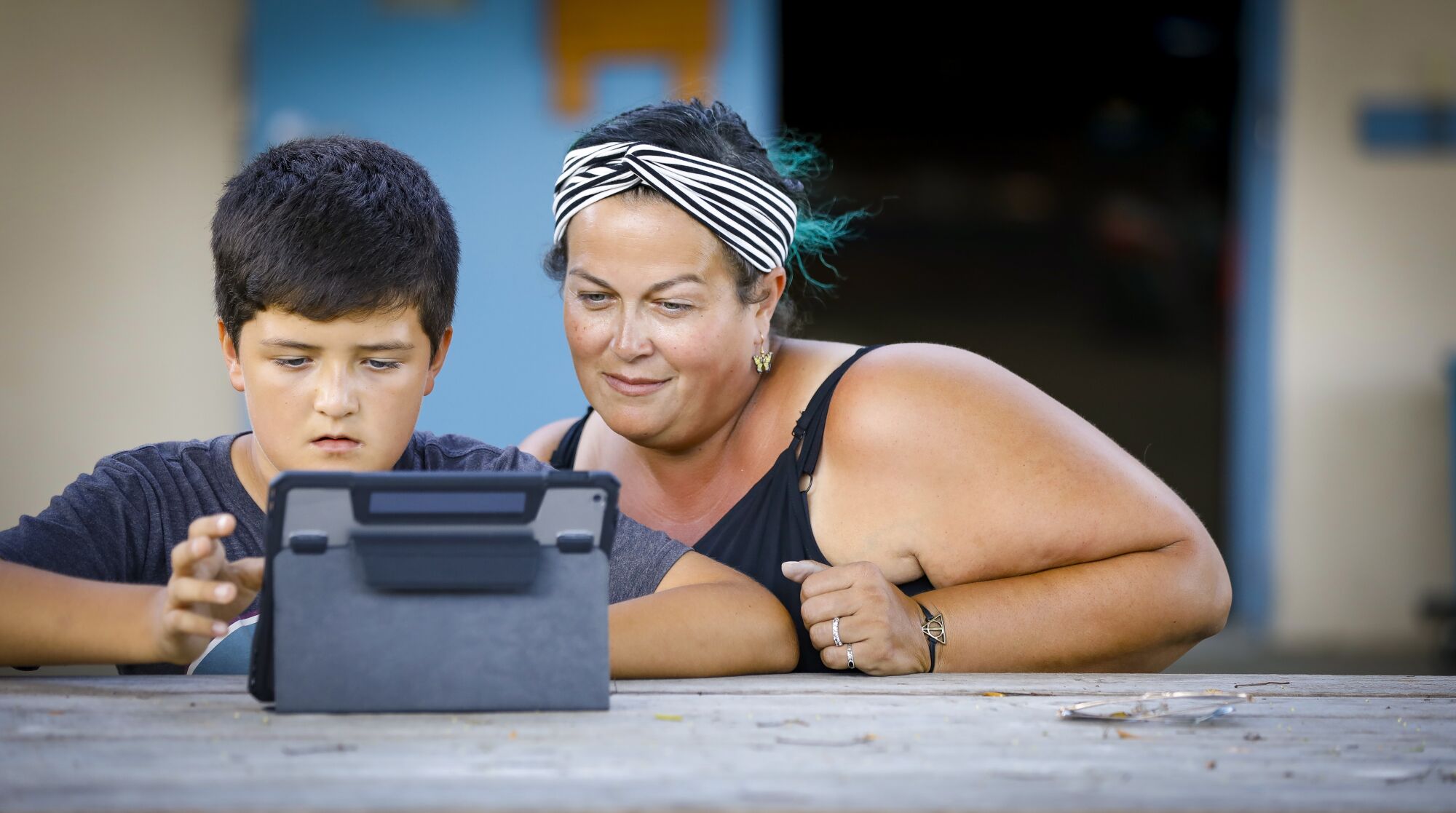 11-year-old fifth grader, Niko Safonov, left, who has epilepsy, and is a student at Ocean Knoll Elementary School in Encinitas, California, does his math homework, as his mom, Melissa Sarenana-Safonov, right, who has adapted her life to provide the best care for him, looks on, September 24, 2019 at the school.