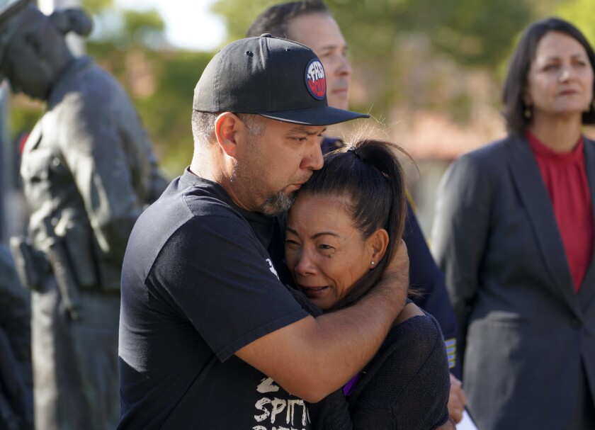 At Chula Vista Police HQ, Maricris Drouaillet is comforted by her husband Robert Drouaillet.