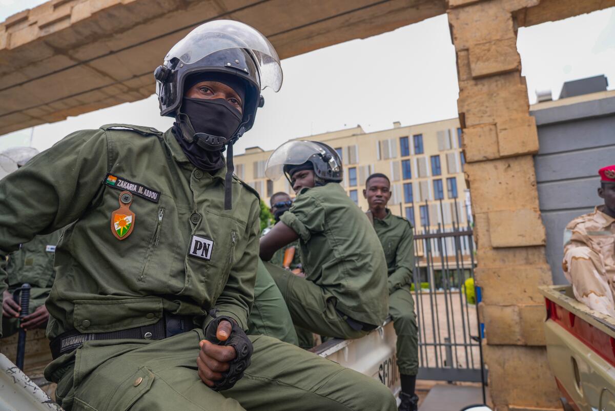 Nigerien police officers sit outside the customs offices in Niamey, Niger.