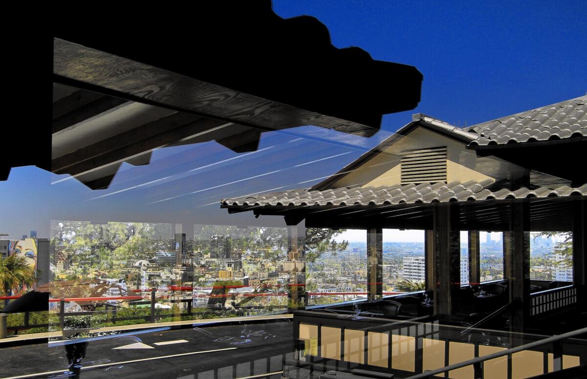 Sweeping views of Los Angeles are captured in reflections at Yamashiro restaurant, a fixture in the Hollywood Hills since the 1960s. A Beijing company bought the building for about $40 million last month, and lease negotiations with the existing operator have broken down.
