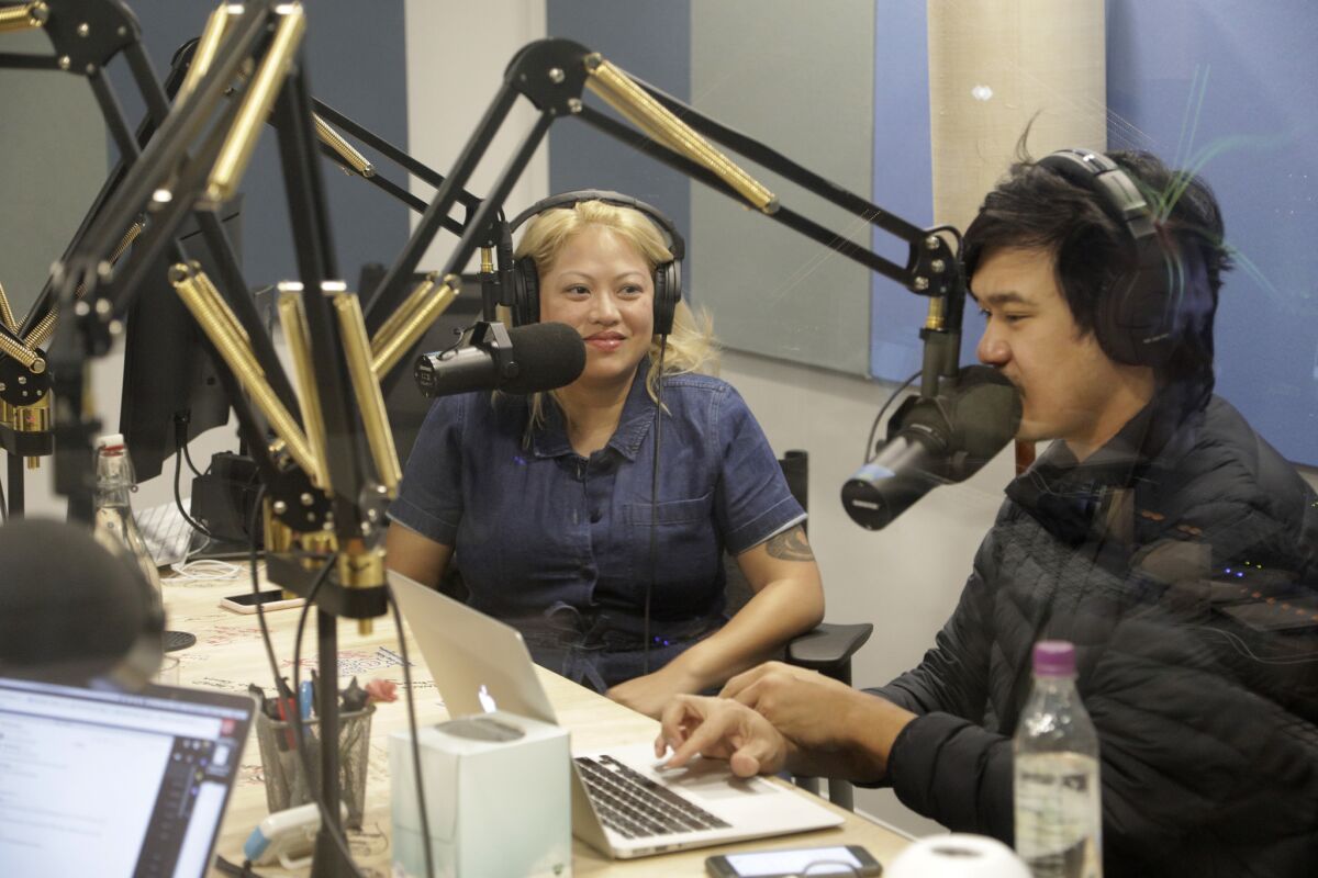 Guest Kulap Vilaysack, left, joins an episode of "Yo, Is This Racist?" with host Andrew Ti at comedy podcasting network Earwolf. The company has expanded to include big-name talents including Conan O'Brien.