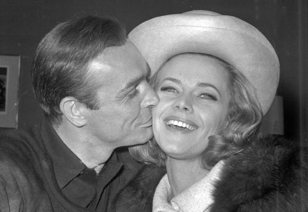 Sean Connery kisses Honor Blackman during a party at Pinewood Film Studios in Iver Heath, England, on March 25, 1964.