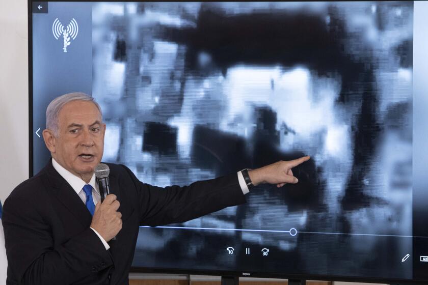 Israeli Prime Minister Benjamin Netanyahu gestures as he shows a slideshow during a briefing to ambassadors to Israel at the Hakirya military base in Tel Aviv, Israel, Wednesday, May 19, 2021. (AP Photo/Sebastian Scheiner, Pool)