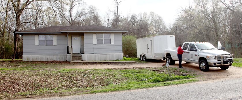 Claiborne County officials prepare to leave a home in Port Gibson, Miss., where authorities were investigating the hanging death of a black man in the neighboring woods.