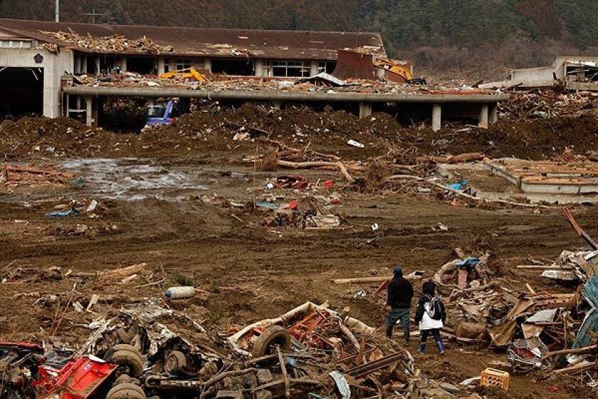 Tatsuhiro Karino and wife Masako search for their daughter, Misaki, 8, at Ookawa Elementary School in Ishinomaki, Japan. He found the body of their son, Tetsuya, 11, earlier in the day. More than 80 students and 10 teachers died in the March 11 earthquake and tsunami.