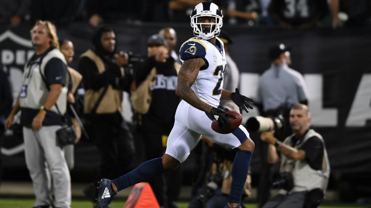 Rams' Marcus Peters runs to the end zone after an interception of Oakland Raiders quarterback Derek Carr in the fourth quarter on Monday.