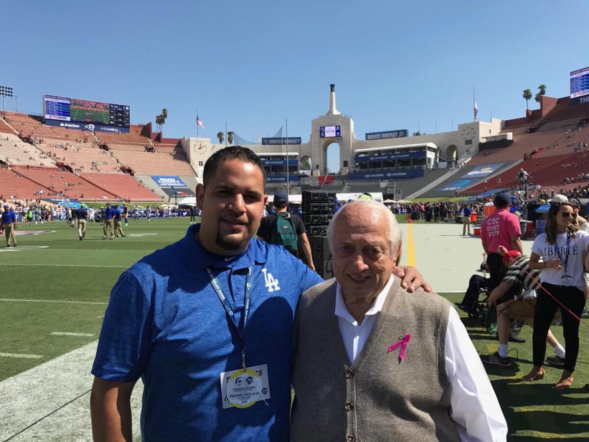 Dodgers legend Tommy Lasorda with his driver, Felipe Ruiz, at the Coliseum in 2019.