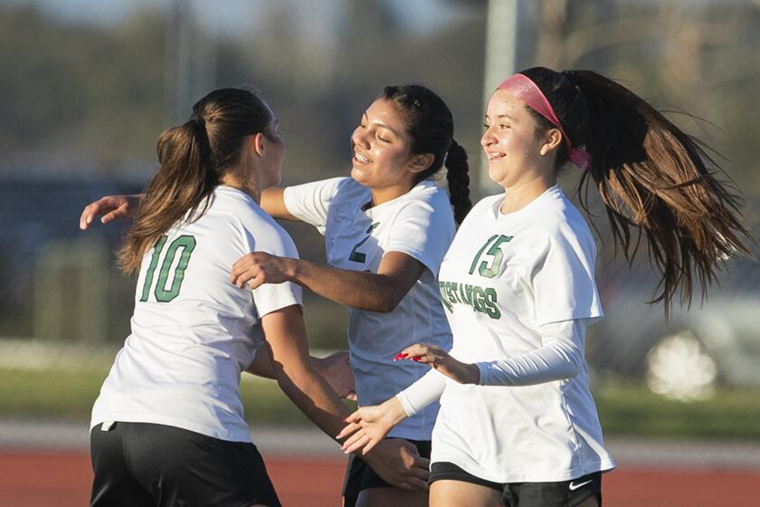 Costa Mesa's Isabelle Whittaker, left, and Brianna Calderon, right, celebrate with Itzel Ramirez after she scored a goal against Estancia in the first half during an Orange Coast League match on Thursday, January 6.