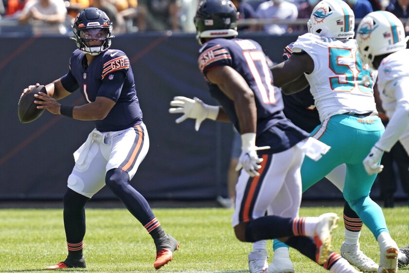 Chicago Bears quarterback Justin Fields, left, prepares to throw the ball against the Miami Dolphins during the second half of an NFL preseason football game in Chicago, Saturday, Aug. 14, 2021. (AP Photo/Nam Y. Huh)