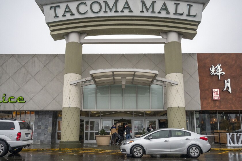 People walk into the north entrance of the Tacoma Mall, Saturday, Nov. 27, 2021, in Tacoma, Wash. A day earlier, multiple shots were fired inside the mall. One person was injured in the shooting. (Pete Caster/The News Tribune via AP)
