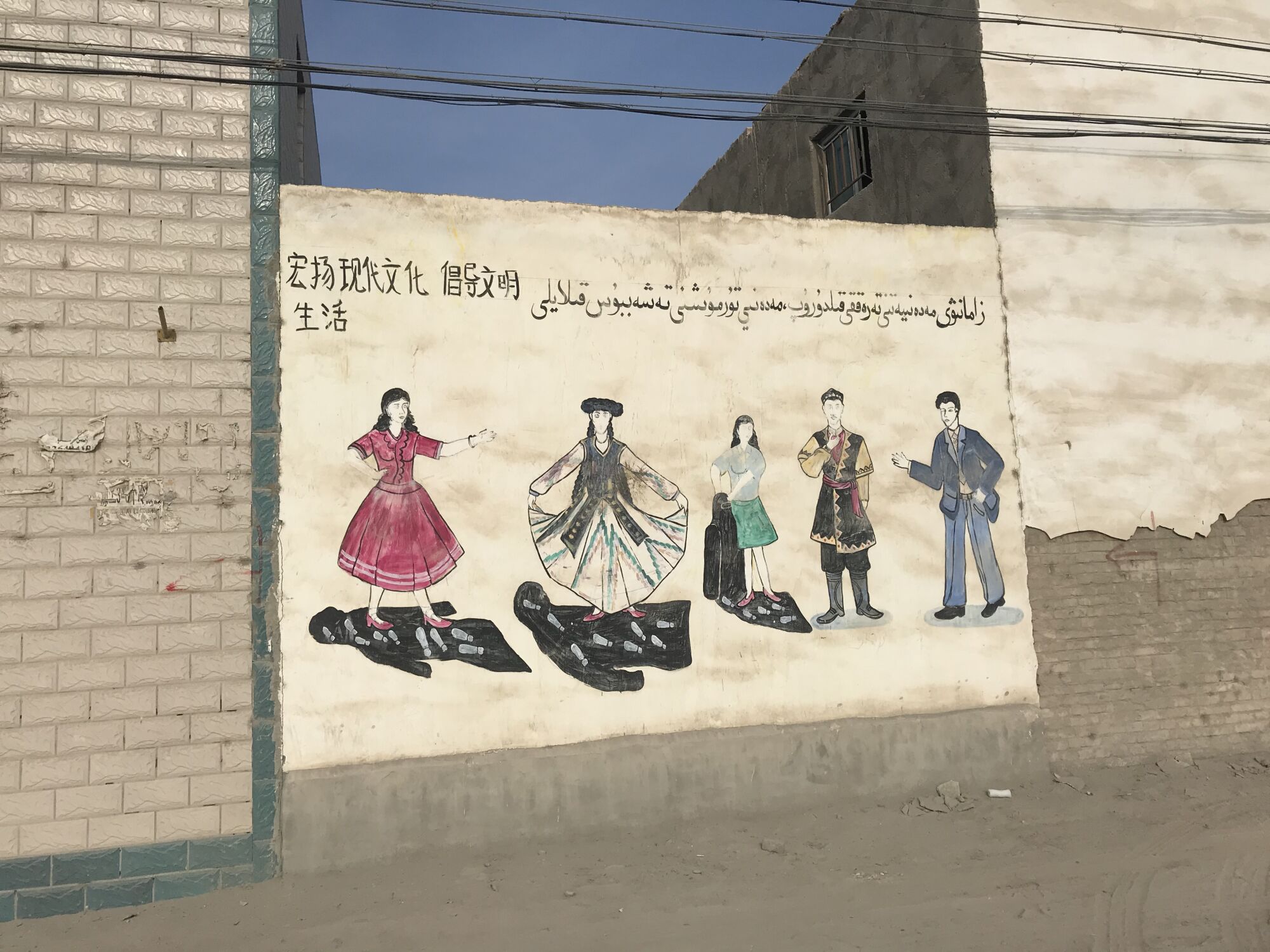 Murals on the walls of a village near Korla, Xinjiang, showed women bursting out of dark veils into colorful clothing.